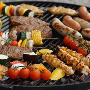 Assorted colorful foods cooking on a grill
